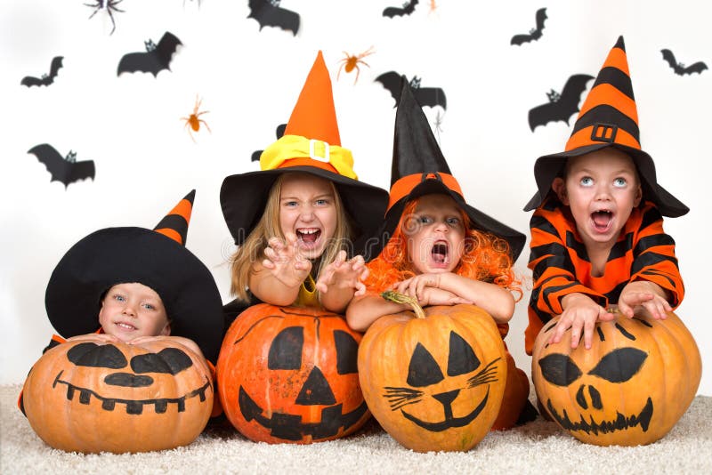 Víspera de Todos los Santos Niños alegres en disfraces de Halloween que celebran Halloween foto de archivo Víspera de Todos los Santos Niños alegres en disfraces de Halloween que celebran Halloween foto de archivo