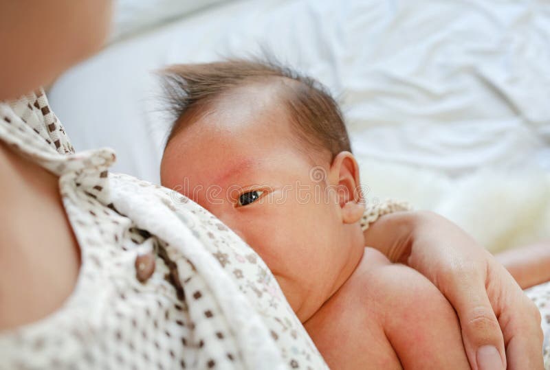 W górę dziecięcego dziecka karmienia od matki breastfeeding jej nowonarodzonego dziecka na łóżku