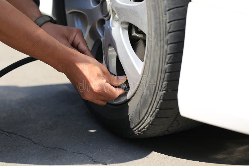 W górę samochodowego mechanika działania i pompować w auto powietrza toczy wewnątrz auto remontowej usługi zdjęcia stock W górę samochodowego mechanika działania i pompować w auto powietrza toczy wewnątrz auto remontowej usługi zdjęcia stock
