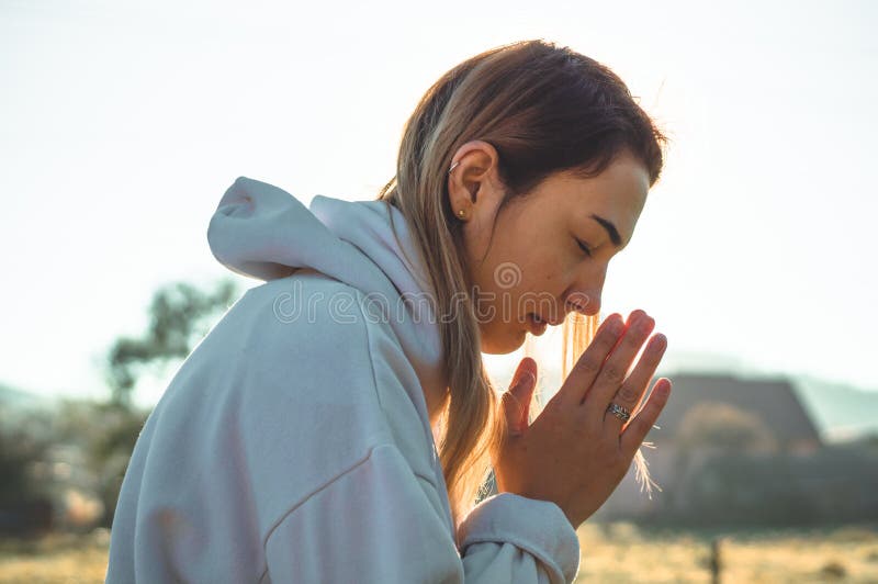 In the morning Girl closed her eyes, praying outdoors, Hands folded in prayer concept for faith, spirituality and religion. Peace, hope, dreams concept. In the morning Girl closed her eyes, praying outdoors, Hands folded in prayer concept for faith, spirituality and religion. Peace, hope, dreams concept.