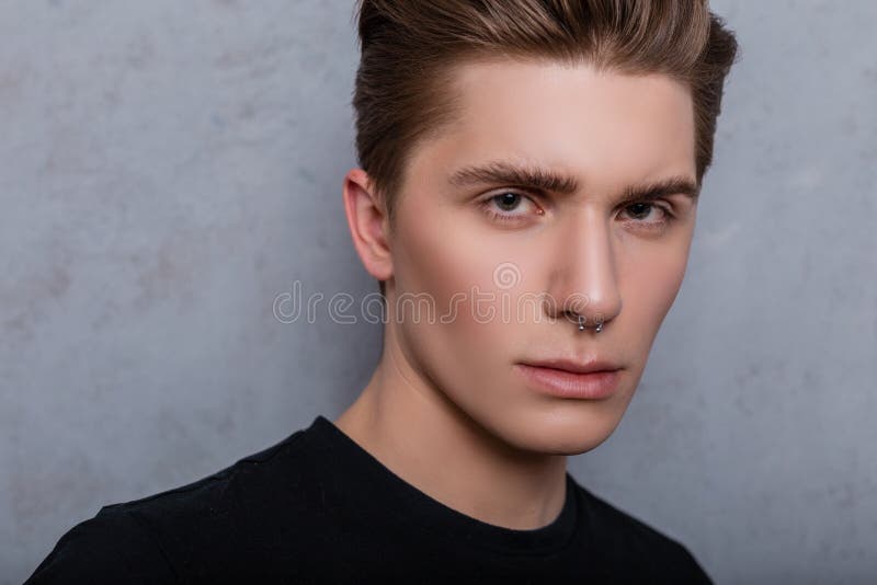 W studio do zamykania portret młodego modnego mężczyzny z czystą skórą z przekłuciem nosa w vintage czarnej koszuli na szarym tle fotografia stock