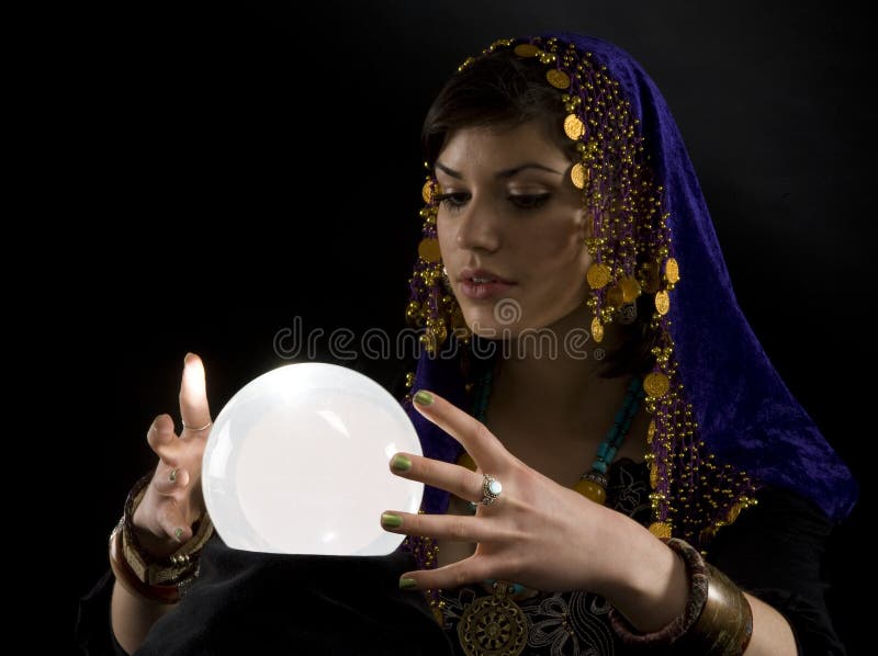 Gypsy fortune-teller uses a crystal ball to foretell the future. Gypsy fortune-teller uses a crystal ball to foretell the future