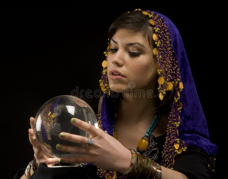 Gypsy fortune-teller uses a crystal ball to foretell the future. Gypsy fortune-teller uses a crystal ball to foretell the future