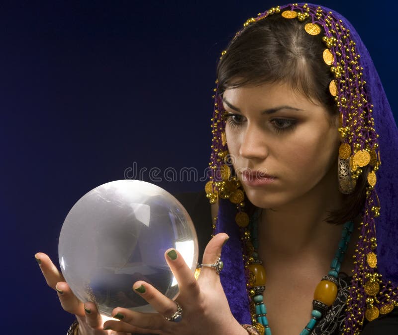 Gypsy fortune-teller uses a crystal ball to foretell the future. Gypsy fortune-teller uses a crystal ball to foretell the future