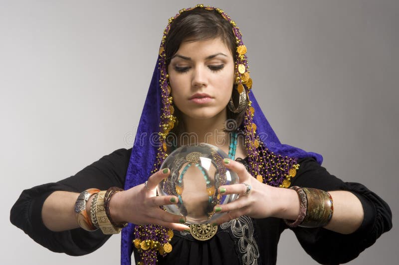 Gypsy fortune-teller uses a crystal ball to foretell the future. Gypsy fortune-teller uses a crystal ball to foretell the future