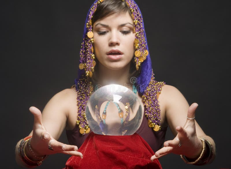 Gypsy fortune-teller uses a crystal ball to foretell the future. Gypsy fortune-teller uses a crystal ball to foretell the future