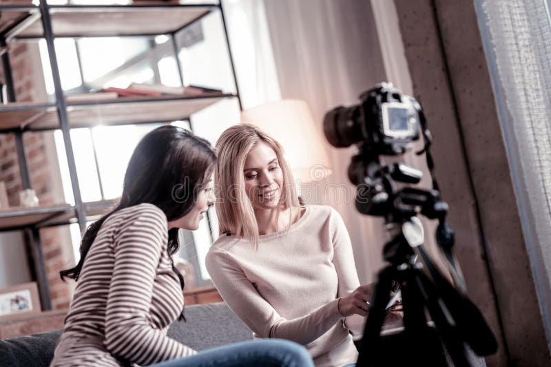 Wachsame Frau, die ihrem Freund Fotos zeigt lizenzfreie stockfotografie Wachsame Frau, die ihrem Freund Fotos zeigt lizenzfreie stockfotografie