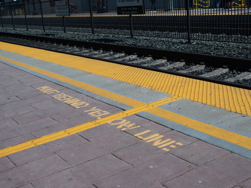 Wacht achter gele lijnwaarschuwing op grond op treinplatform royalty-vrije stock foto's Wacht achter gele lijnwaarschuwing op grond op treinplatform royalty-vrije stock foto's