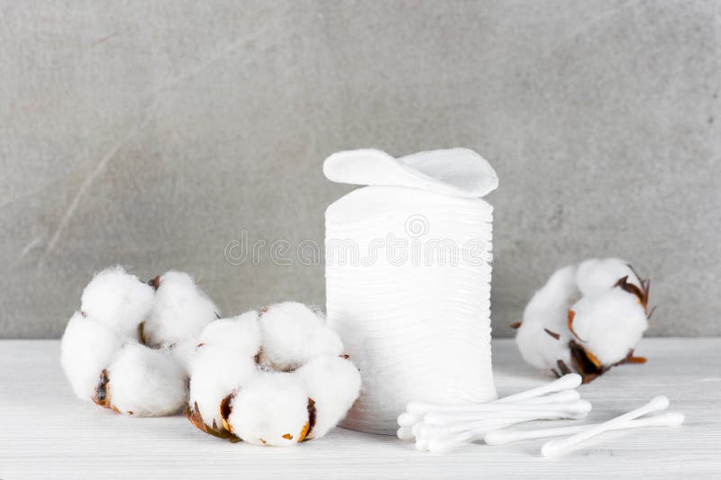 Wadded pads, sticks and cotton flowers on the wooden table