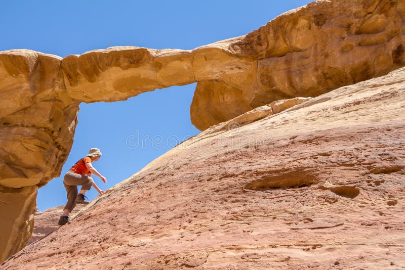 WADI RUM DESERT, JORDAN - APRIL 30, 2016: Climbing Burdah rock bridge royalty free stock photography WADI RUM DESERT, JORDAN - APRIL 30, 2016: Climbing Burdah rock bridge royalty free stock photography