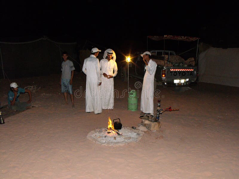 Three men prepare dinner at a Bedouin camp in the Wadi Rum desert, Jordan