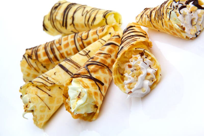Wafer rolls with cream topped with nuts and chocolate. Serve vanilla stock images, royalty-free photos and pictures