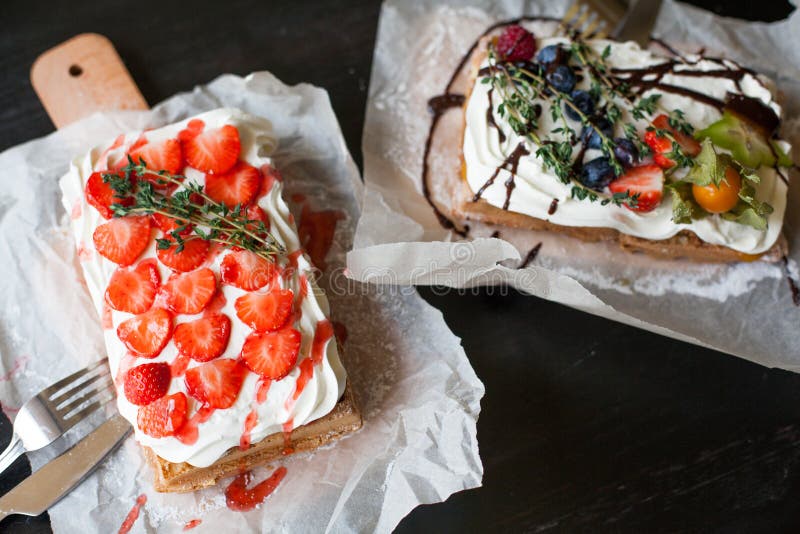 Waffels belgas con las bayas frescas y la crema azotada en tabla de cortar en estilo rústico en la tabla negra Concepto del desay imagen de archivo libre de regalías Waffels belgas con las bayas frescas y la crema azotada en tabla de cortar en estilo rústico en la tabla negra Concepto del desay imagen de archivo libre de regalías