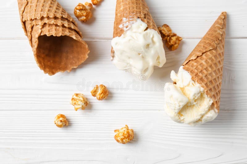 Waffle Cones with Delicious Ice Cream and Popcorn on White Table Stock