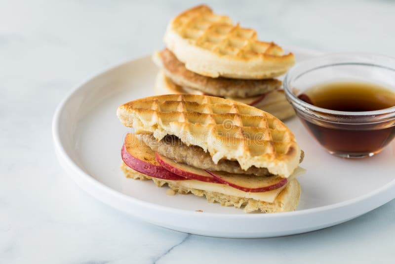 A Waffle and Sausage Sandwich Served with Maple Syrup for Dipping