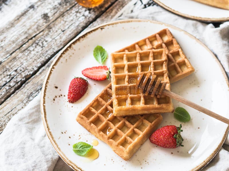 Waffles Belgas Com Mel E Morangos Em Uma Placa Branca Imagem de Stock
