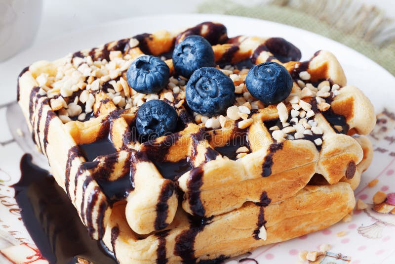 Waffles belgas com molho de chocolate do amendoim e mirtilo, uva-do-monte, mirtilo, mirtilo, hurtleberry, blaeberry imagens de stock royalty free Waffles belgas com molho de chocolate do amendoim e mirtilo, uva-do-monte, mirtilo, mirtilo, hurtleberry, blaeberry imagens de stock royalty free