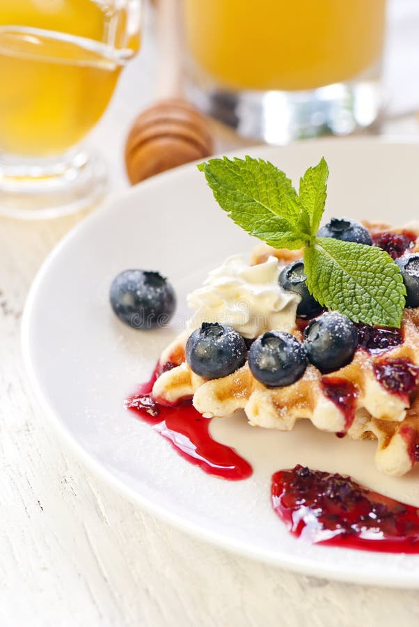 Waffles с сливк и ягодами стоковая фотография Waffles с сливк и ягодами стоковая фотография
