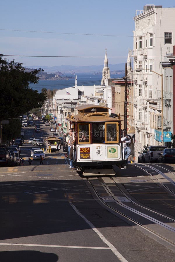 Wagon kolei linowej na górze San Francisco wzgórza z zatoki wodą w tle obraz royalty free Wagon kolei linowej na górze San Francisco wzgórza z zatoki wodą w tle obraz royalty free