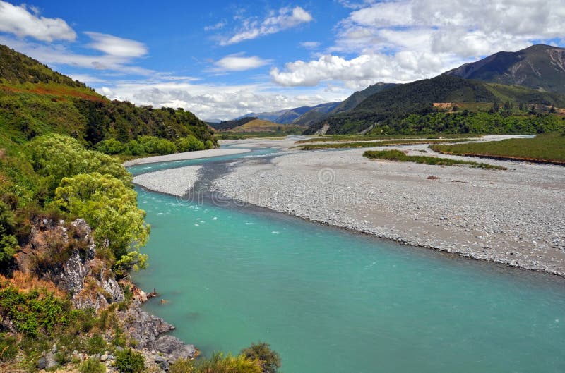 The torquoise waters of the Waiau River flowing through North Canterbury. In the distance is the Lewis Pass and the Southern Alps of New Zealand. The torquoise waters of the Waiau River flowing through North Canterbury. In the distance is the Lewis Pass and the Southern Alps of New Zealand.