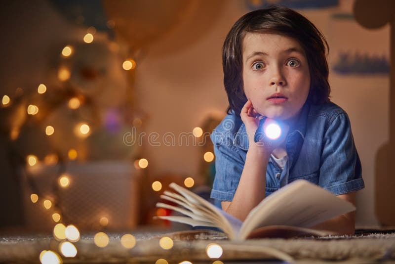 Astonished child hold in hand flashlight