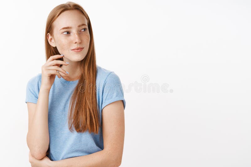 Waist-up shot of flirty intrigued and interested good-looking adult redhead female with freckles in blue t-shirt turning stock images Waist-up shot of flirty intrigued and interested good-looking adult redhead female with freckles in blue t-shirt turning stock images