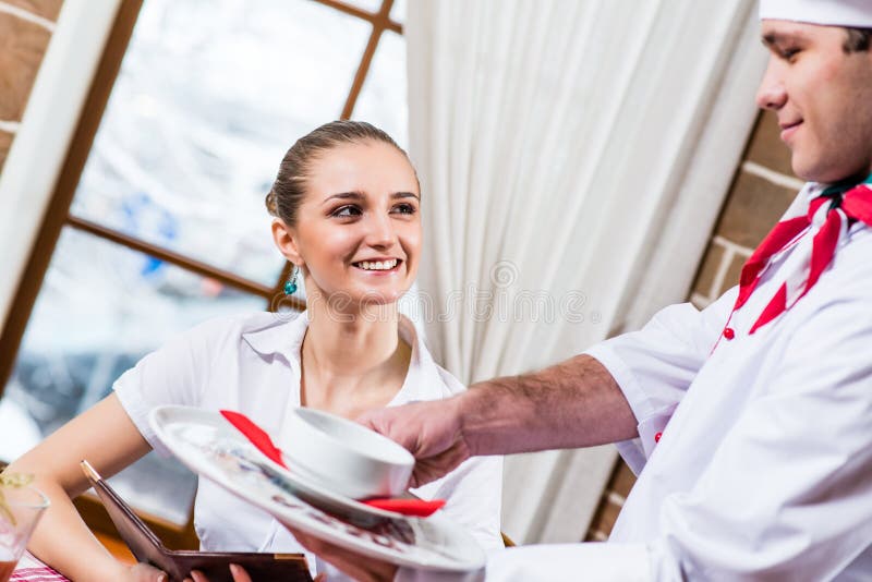 Waiter brings a dish for a nice woman