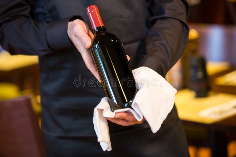 Waiter holding a bottle of red wine