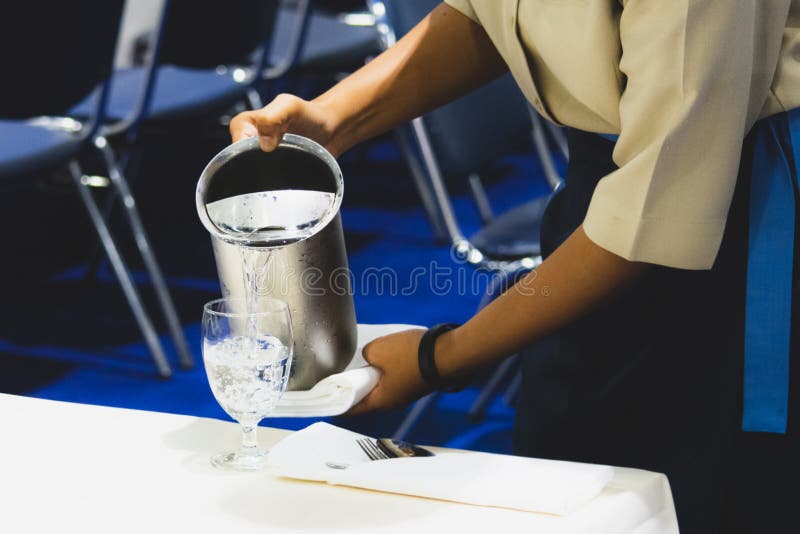 Waiter Pouring Wine To the Glass on the Table Dinner Stock Image