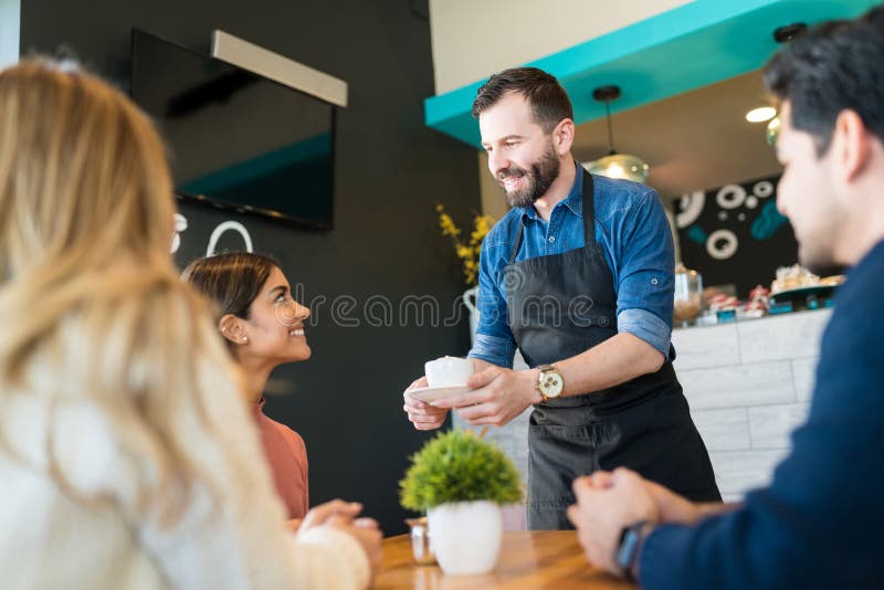 Waiter Serving Drinks To Customers at Cafe Stock Image Image of table
