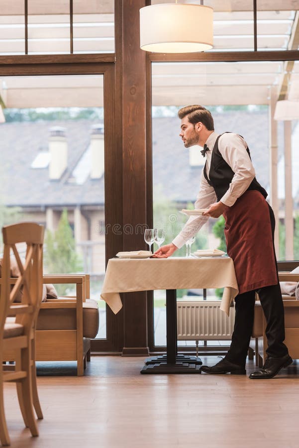 Waiter Serving Plates on Table Stock Photo Image of male, luxury