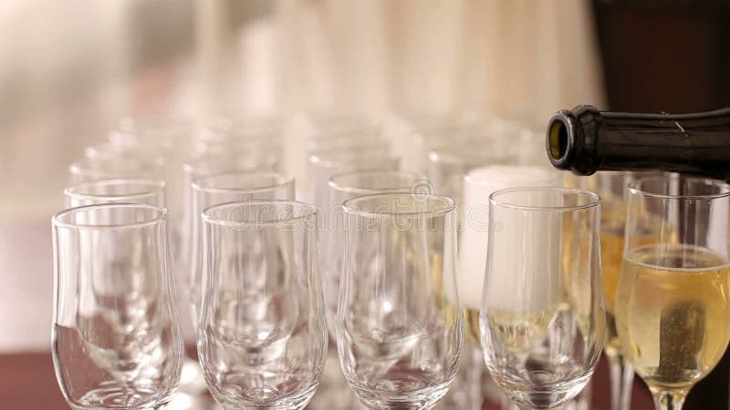 Waiters pour champagne into glasses close-up.