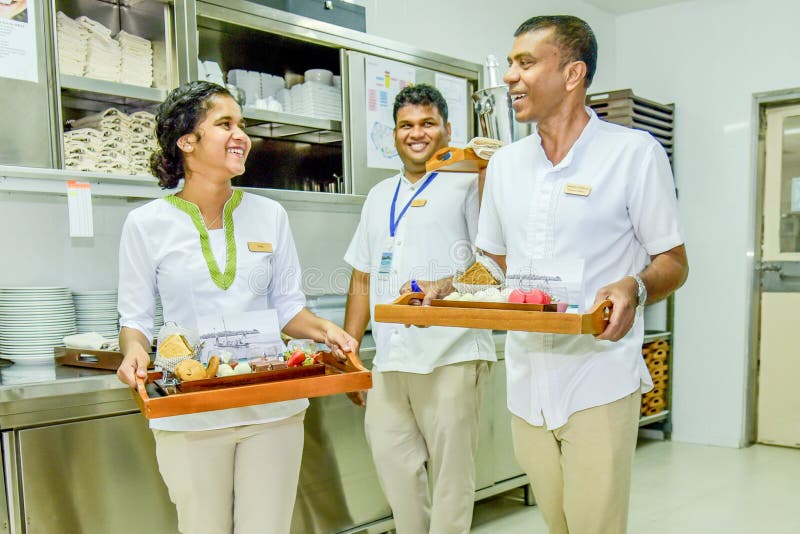 Waiters and waitress team smiling with trays full of dishes in the kitchen stock image Waiters and waitress team smiling with trays full of dishes in the kitchen stock image