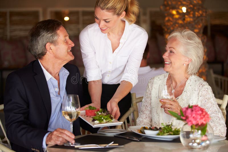 Waitress Serving Food To Senior Couple In Restaurant royalty free stock photos Waitress Serving Food To Senior Couple In Restaurant royalty free stock photos