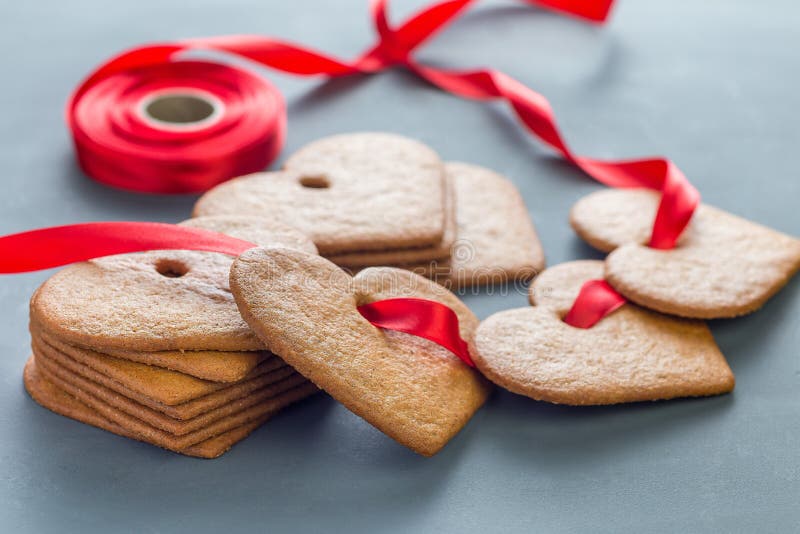 Wakacyjni cukierki Szwedzkich bożych narodzeń ciastek piernikowy pepparkakor, dekorujący z czerwonym faborkiem na zmroku, - szary fotografia royalty free Wakacyjni cukierki Szwedzkich bożych narodzeń ciastek piernikowy pepparkakor, dekorujący z czerwonym faborkiem na zmroku, - szary fotografia royalty free