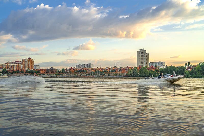 Wakeboarder auf dem wakeboard, das für hinteres Boot an Damm Kyiv Obolon geht Ansicht vom Wasser von Dniep lizenzfreie stockbilder Wakeboarder auf dem wakeboard, das für hinteres Boot an Damm Kyiv Obolon geht Ansicht vom Wasser von Dniep lizenzfreie stockbilder