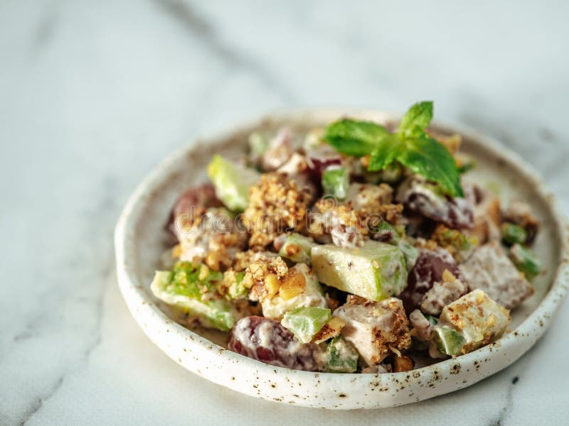 Waldorf salad on white marble, copy space