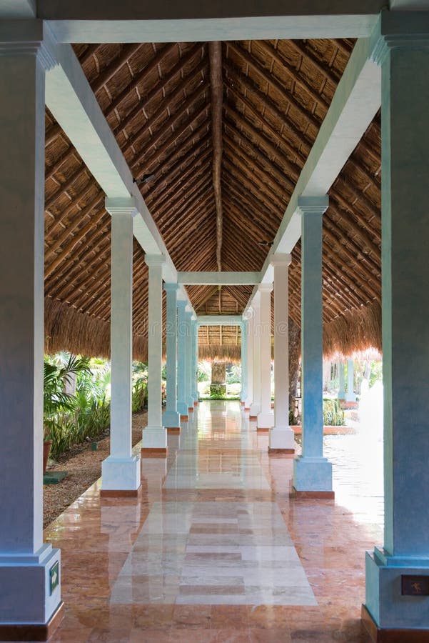 Walk path under palm tree leaf roof with slippery pollished stone floor