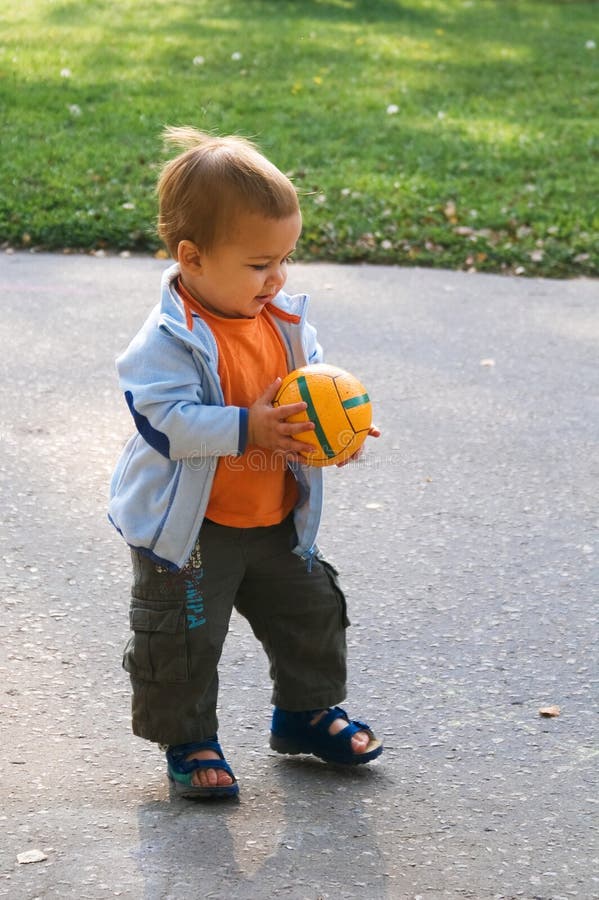 Walking baby with ball in his hands