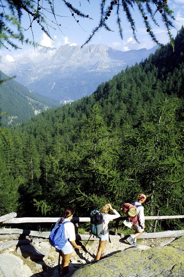 Traja chlapi chodiť na horskej ceste v Valle Orco Taliansku.