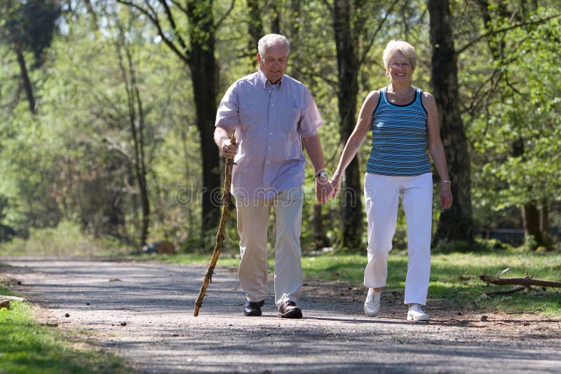 Älteres Ehepaar zu Fuß durch den Park hand in hand.