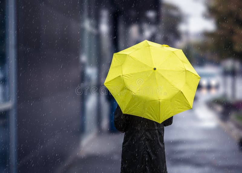 Walking on rainy day with yellow umbrella