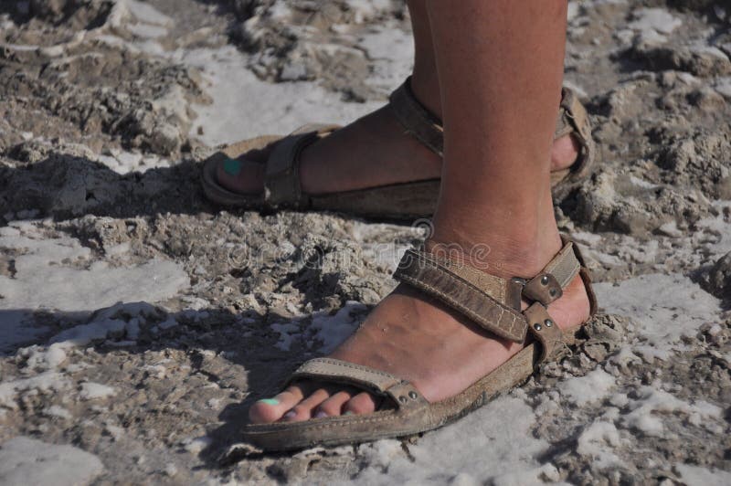 They are walking in sandals on the bottom of a dried and cracked lake Akrotiri in Cyprus royalty free stock photos
