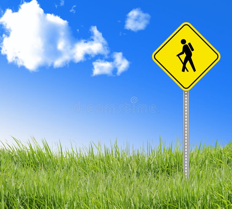 Walking sign on green grass and blue sky.