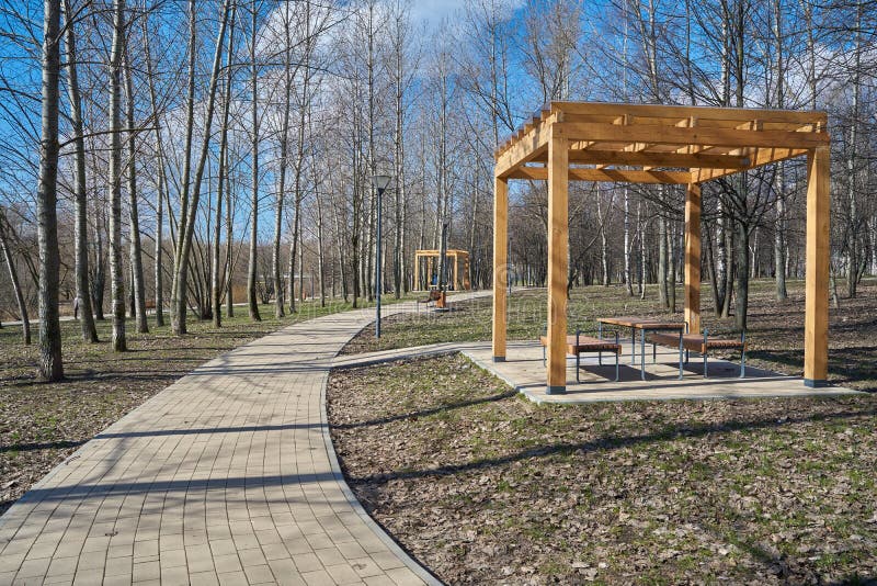 Pedestrian walkway and wooden pergolas in the park in springtime in Yuzhnoye Medvedkovo district, Moscow. Pedestrian walkway and wooden pergolas in the park in springtime in Yuzhnoye Medvedkovo district, Moscow