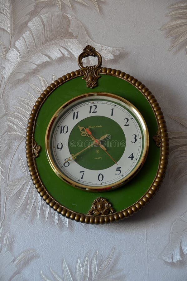Wall Clock in a Green Rim, Decorated with Decorative Elements Stock