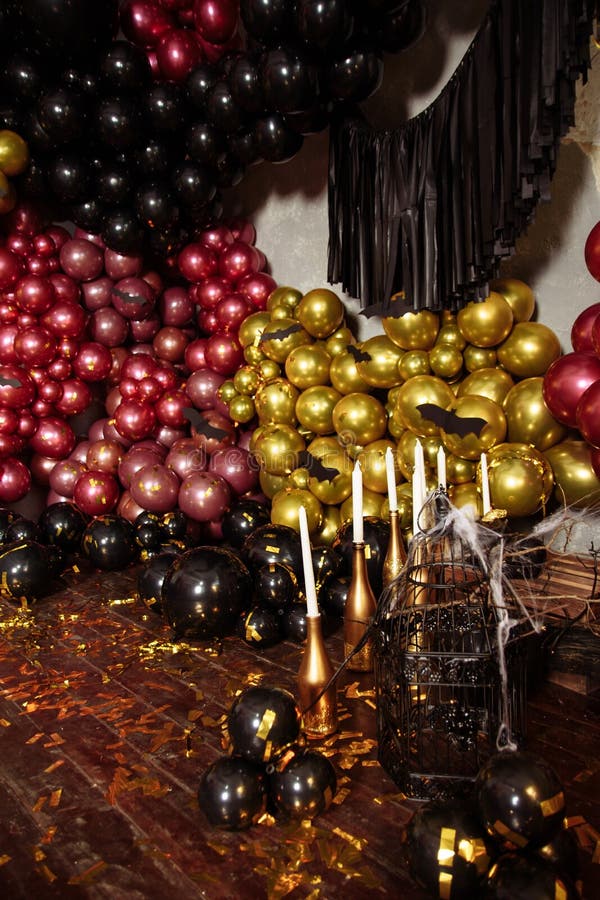 The wall is decorated with purple and black balloons. Halloween decor.