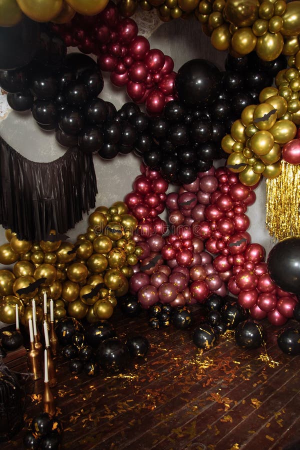 The wall is decorated with purple and black balloons. Halloween decor.