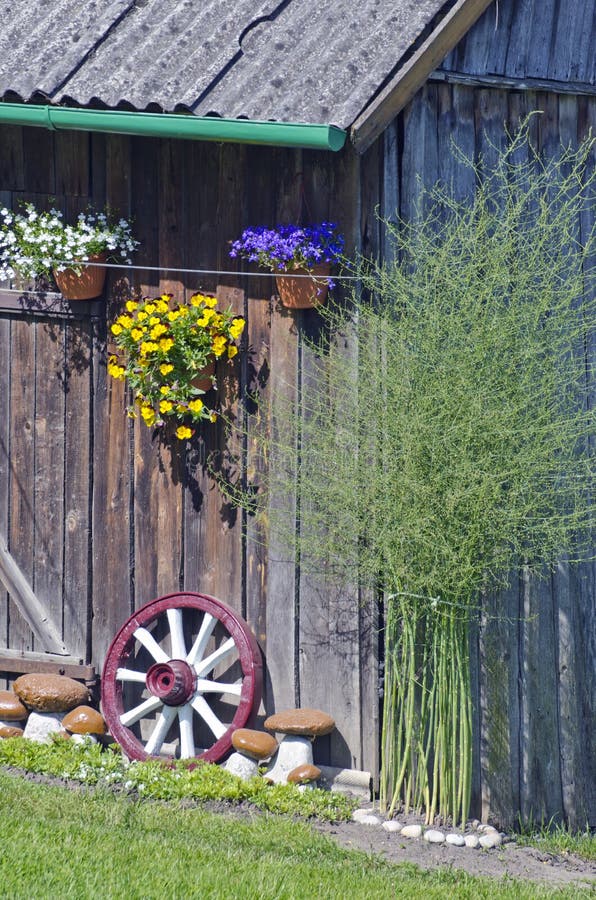 Wall decorations in farm - flowers, stone and carriage wheel