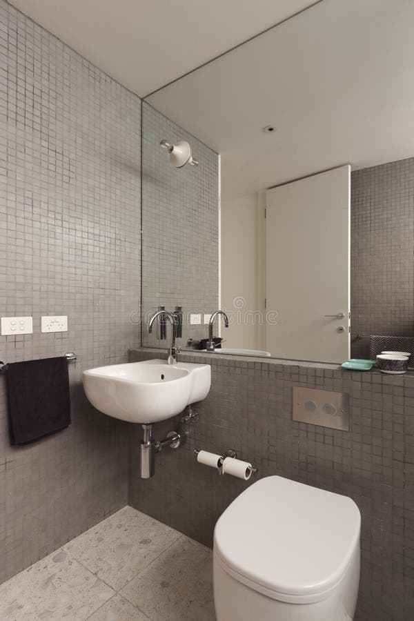 Wall mounted basin vanity in fully tiled mosaic bathroom
